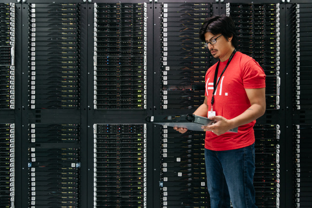 A Hivelocity employee standing next to a cabinet of servers