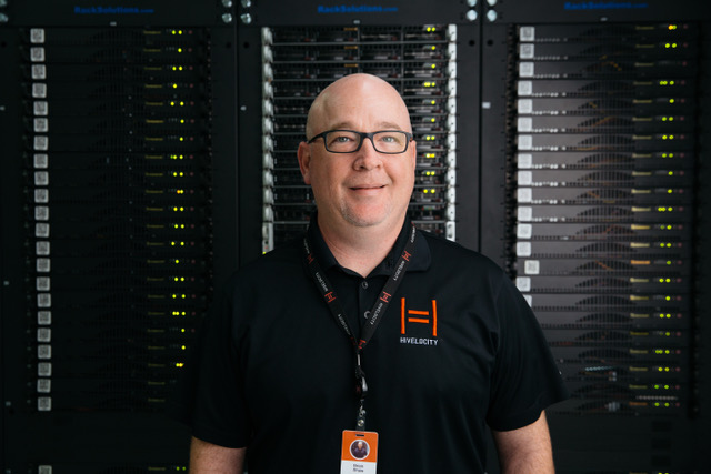 A Hivelocity employee standing in front of several racks of servers