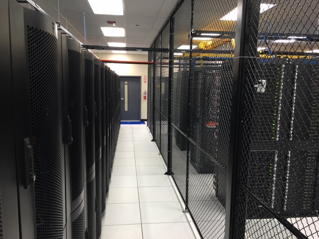 A server room full of server cabinets stored in secured cages