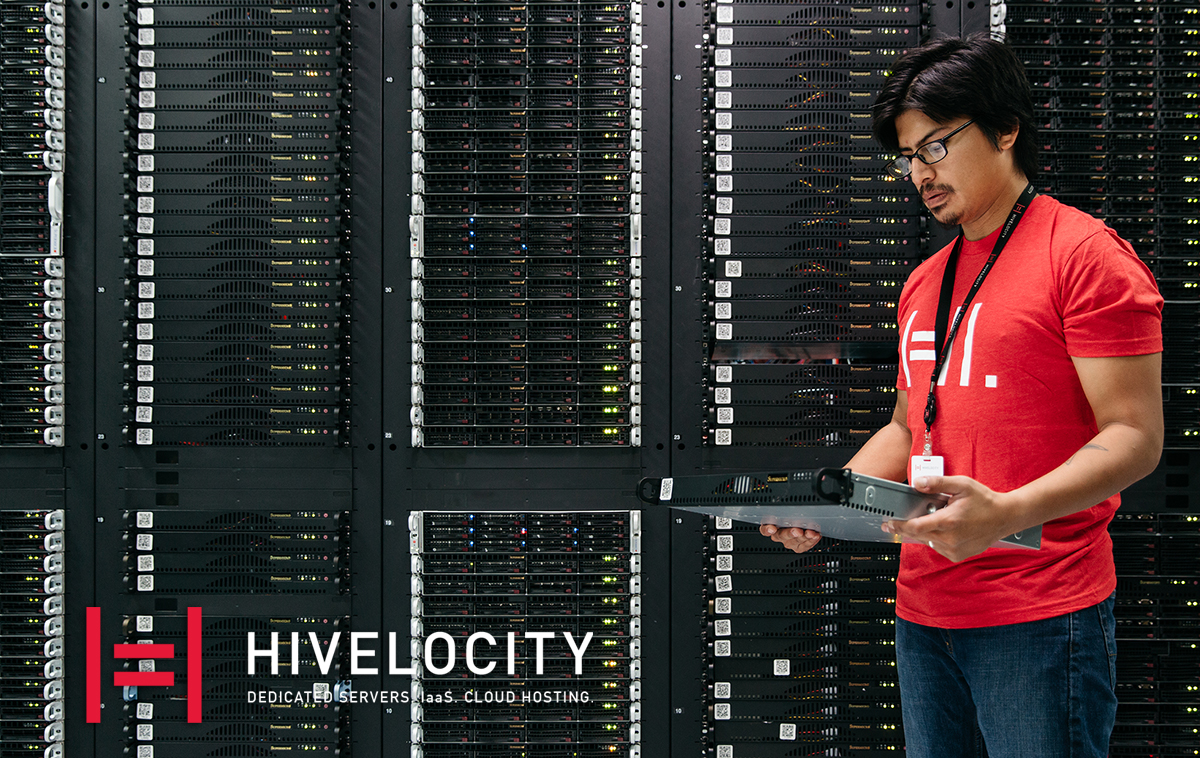 Hivelocity logo on an image of a man holding a server in front of several server cabinets