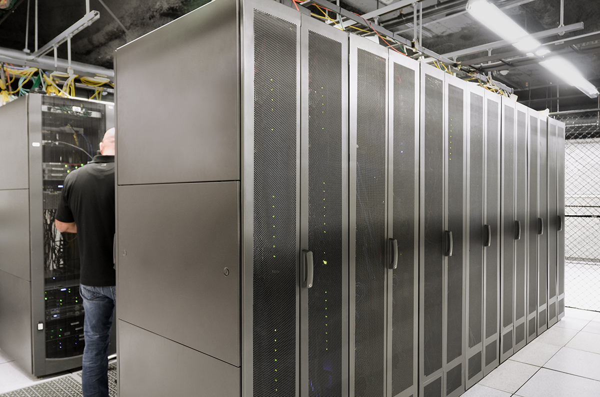 A Hivelocity employee standing between rows of filled server cabinets