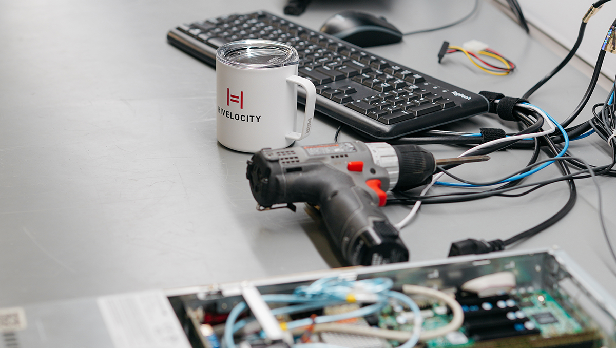 A server being build sitting next to a coffee mug featuring the Hivelocity logo